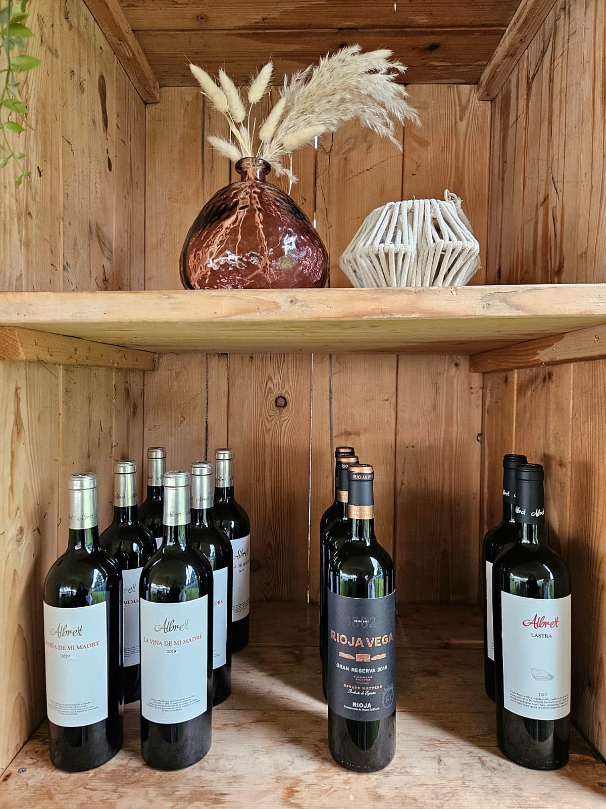 Flessen Albret en Rioja Vega in een houten kast